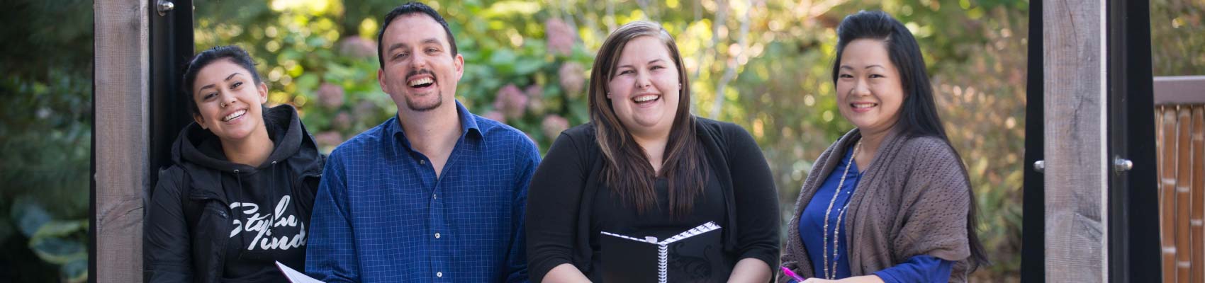 Four UFV students sitting on an outdoor bench and smiling